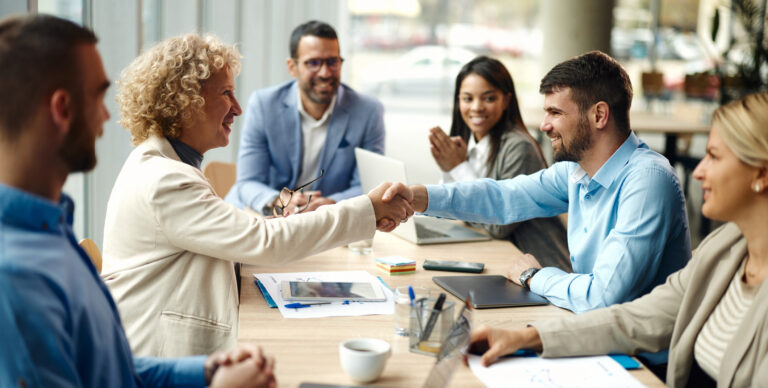 Happy entrepreneurs came to a successful deal on a meeting in the office.