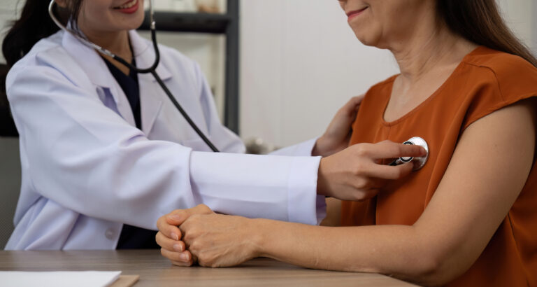 Female doctor and elderly female patient who are undergoing their annual health check-up at the clinic, using a stethoscope to examine patients 
